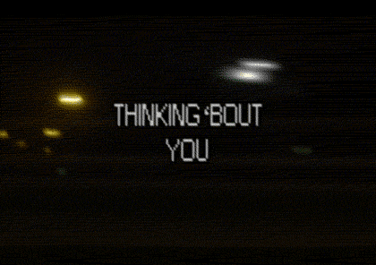 Video gif. Lo-fi video footage of what looks like a nighttime streetscape. Text, "Thinking 'bout you."
