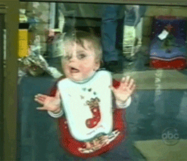 Video gif. A child presses his face and hands up to a glass door, licking the glass while swiping his mouth left and right in a Z formation.