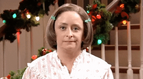 como se diz o feriado cai no sábado em ingles
DESCRIÇÃO DA IMAGEM: Cena do programa "Saturday Night Live". Uma mulher de cabelo chanel com presilhas na franja está olhando fixamente para a câmera com uma cara de incomodada. Ao fundo, vemos decorações de Natal.