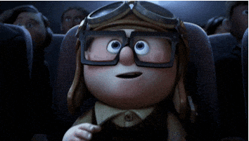 Cartoon gif. An awestruck young Carl Fredricksen from Up wears an aviator cap while watching a movie in a theater. He pulls goggles over his eyes, and gives a smiling thumbs-up to the screen.