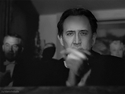Celebrity gif. Nicolas Cage's face is superimposed over Orson Welles as Charles Foster Kane in Citizen Kane, clapping his hands slowly in a theater.