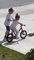 Brother Teaches Younger Sister How to Ride a Bicycle