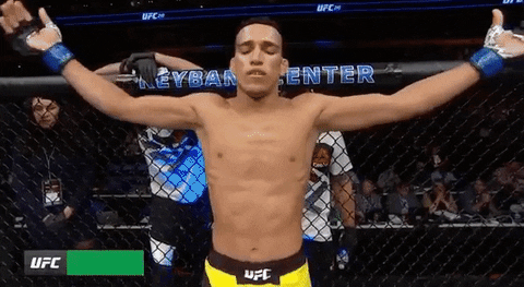 Sports gif. Charles Oliveira holds his arms out, then crosses himself, kisses his finger and raises his hand to the sky.