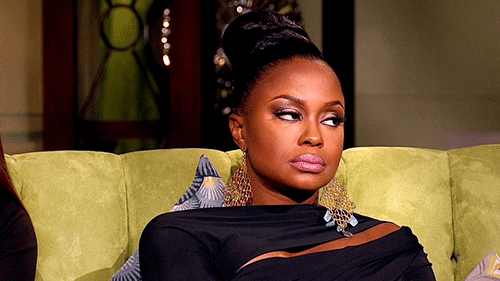 Reality TV gif. Phaedra Parks from The Real Housewives of Atlanta sits in a chair and rolls her eyes, looking extremely displeased and unamused. 