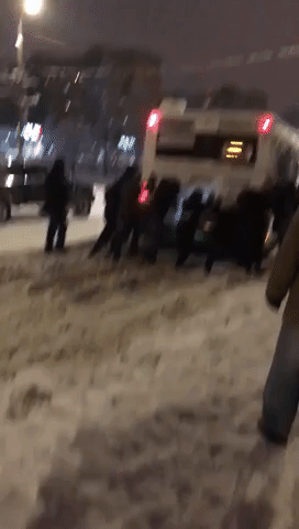 Passersby Struggle to Push Bus Stuck in Snow as Moscow Battles Treacherous Weather