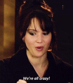 Celebrity gif. Jennifer Lawrence smiles and shakes slightly while she looks at us with wide eyes, saying, "We're all crazy!"
