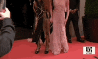 Met Gala 2024 gif. Phoebe Dynevor wearing an ethereal Victoria Beckham gown, poses for the cameras holding hands with Charlotte Tilbury.