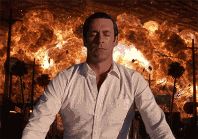 Digital art gif. Jon Hamm as Don Draper, eyes closed in relaxed meditation, his face melting into an untroubled smile, an entire city exploding in flames behind him.
