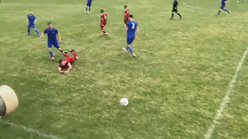 English Assistant Soccer Coach 'Nutmegs' Opposing Player From Sidelines