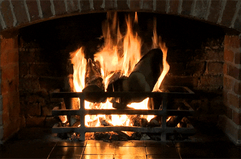 Video gif. Fire crackles in brick fireplace.