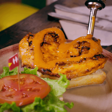 Ad gif. Nando's Peri-Peri Sauce is applied in a heart shape on the chicken of a sandwich.