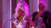 Reality TV gif. A contestant about to perform on RuPaul's Drag Race sharply looks over and gasps in shock at someone they've seen.