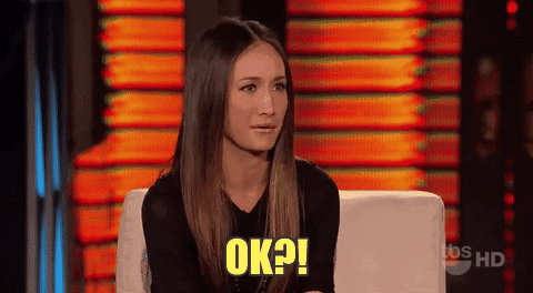 TV gif. As a guest on a talk show, Maggie Q furrows her brow and shakes her head slightly, then smiles, seemingly taken aback, while saying, "Ok?!" which appears as text.