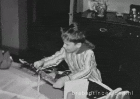 Video gif. Black and white home-movie style video of a young boy wearing a long night shirt looking at us while jumping and clapping with excitement. Text, "Yay."