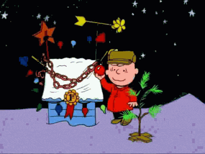 Peanuts gif. Charlie Brown takes a red ornament from Snoopy’s award-winning Christmas decorated dog house and attaches it to his tiny Christmas tree, and smiles. The sad tree slowly collapses under the weight of the ornament as Charlie Brown covers his eyes and backs away in horror.