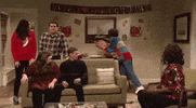 SNL gif. Kristen Wiig as Sue in a Thanksgiving skit rashly throws a whole turkey to break down a door and bolt through. The rest of the guests at the Thanksgiving party watch in absolute disbelief.