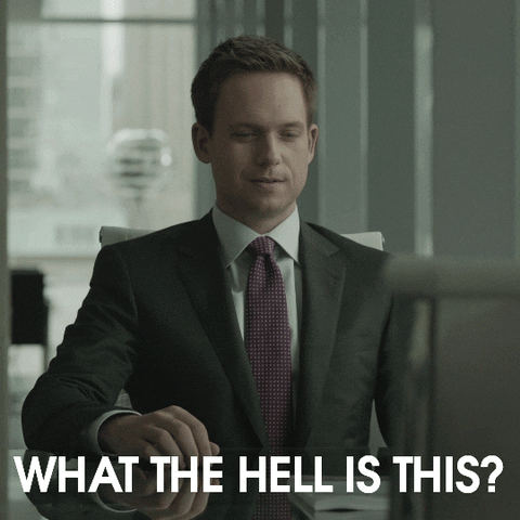 TV gif. Patrick J. Adams as Mike in Suits looks down and tosses up a hand as he says, "What the hell is this?"