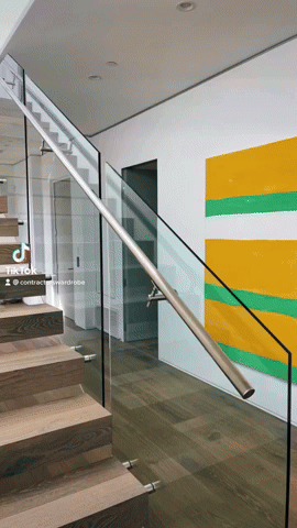 Glass rail staircase complemented by works of art