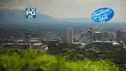 Reality TV gif. A montage from American Idol, showing quick clips of Salt Lake City, a bus, and a man holding a sign that says "Dream big."