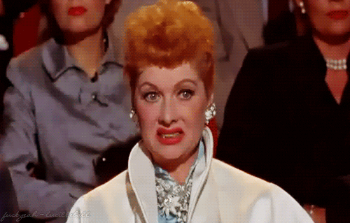 TV gif. Lucille Ball sits in a crowd of people. She pulls her lips back and grimaces in disgust like she wants to look away, but can't. 