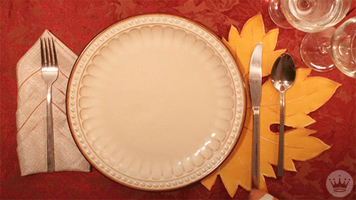 Video gif. A football of turkey breast flies through a green bean goal post against a dinner plate backdrop before a traditional Thanksgiving meal fills the plate. 