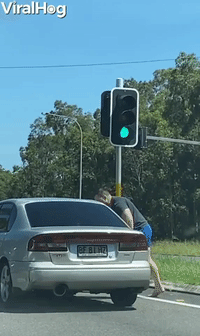 Angry Man Attacks Car at Intersection