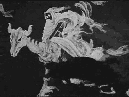 Disney gif. Ghostly caped figure from Fantasia rides a ghostly horned animal through billows of mist.