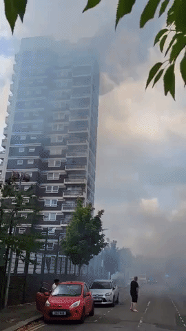 Grass Fire Burns Across Street From Apartment Fire in London