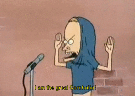 Cartoon gif. Beavis from Beavis and Butt-Head standing at a microphone with his shirt partially pulled over his head and his arms up. Text, "I am the great cornholio!"