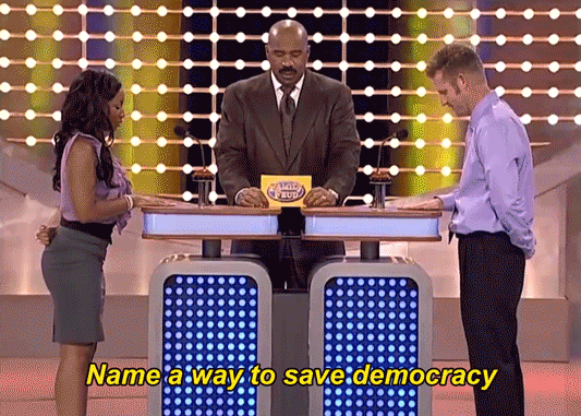 TV gif. Two contestants face off in front of Steve Harvey on Family Feud. Steve Harvey says, “Name a way to save democracy.” The contestants slap the buzzer, the woman making it to the buzzer first. She says, “Become a poll worker.” Steve Harvey points to the board where “Poll worker” pops up on the ranking as the number two answer.