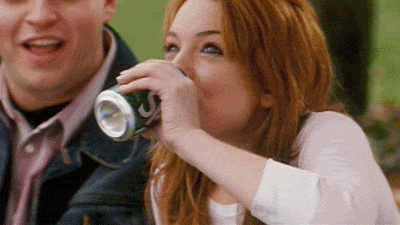 Celebrity gif. Lindsay Lohan drinks a can of Sprite and then does a spit take, sputtering it out.