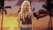 Music Video gif. Olivia Rodrigo in her music video for her song, Brutal. She has platinum blonde hair and pink tears running down her face. She crosses her arms in frustration and looks to the side while pouting.