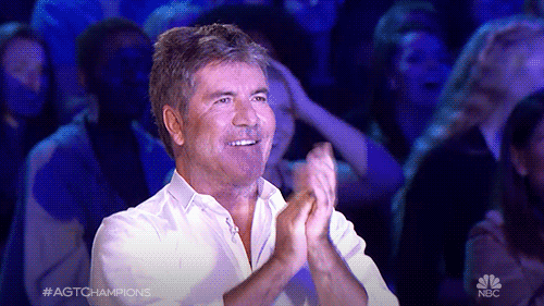 Reality TV gif. A smiling Simon Cowell on America’s Got Talent claps enthusiastically.