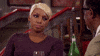 Video gif. A woman stares as if annoyed to the man who speaks at her. 