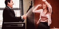 The Office gif. Steve Carrell as Michael Scott shakes and sprays a bottle of champagne at Ellie Kemper as Erin as she waves her arms and cheers excitedly.