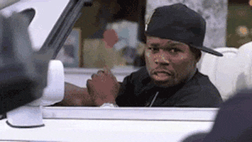 Celebrity gif. Fifty cent rests a hand on a steering wheel of a convertible and laughs as he drives off. 