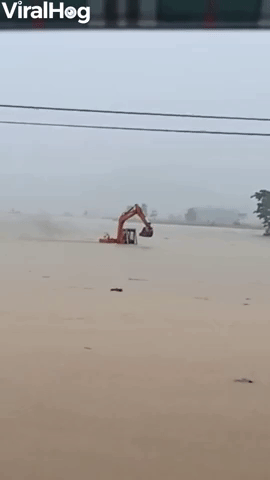Excavator Returning to Shore Wades Against Floodwa