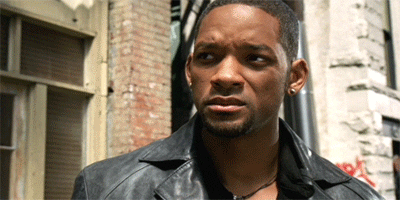 Movie gif. Will Smith as Del in I, Robot stands on a city street and shakes his head in disgust before turning to walk away.