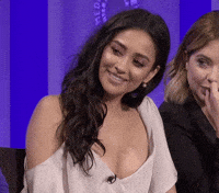 Celebrity gif. Shay Mitchell on a panel at the Paley Center for Media looking over at someone with gratitude and touching her hand to her heart.