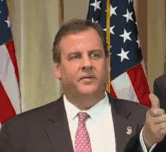 Political gif. Chris Christie stands to the side of someone speaking, looking confused as his eyes dart back and forth.