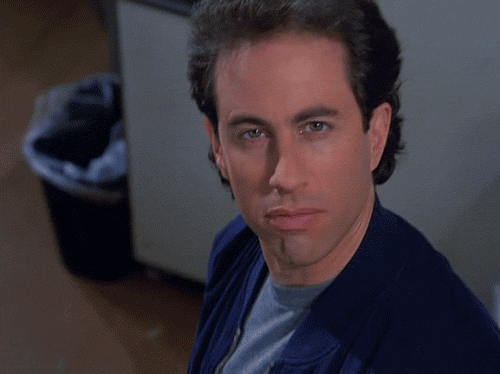 Seinfeld gif. Jerry Seinfeld looks at us coolly before his face breaks into an exaggerated shocked expression.