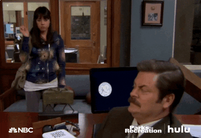 Parks and Recreation gif. Aubrey Plaza as April chucks a highlighter at Nick Offerman as Ron's head, but he doesn't react.