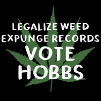 Digital art gif. Green marijuana leaf on a black background with a message in white marker font, "Legalize weed, expunge records, Vote Hobbs."