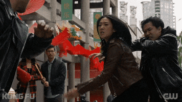 TV gif. Olivia Liang as Nicky in Kung Fu. She's fighting a pair of goons who have attacked her and she beats them down, punching one in the gut and kicking the other.