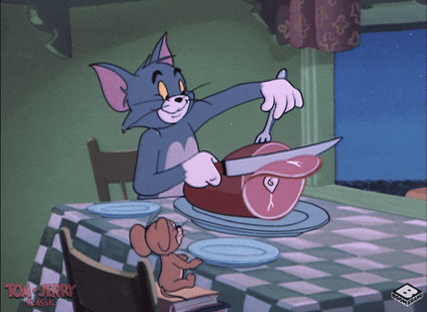 Cartoon gif. Tom and Jerry sit at a dining table as Tom cheerfully slices a piece of ham then puts it on Jerry's plate. Jerry leans forward in anticipation and smells it happily as Tom starts to cut another slice. 