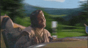 Star Wars gif. Anakin Skywalker, bobbing around happily, pilots a mini spaceship through a beautiful landscape, passing various Star Wars characters as he goes.