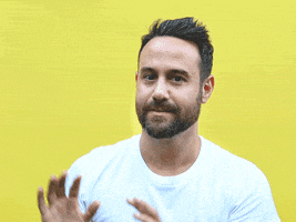 Video gif. Mike Bruno flinches, missing the basketball thrown at him against a yellow background.