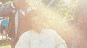 Celebrity gif. Yvette Nicole Brown gets ready on set with her hair wrapped in rollers. Sunlight glistens as she gives us an excited wave.