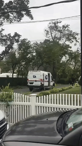 US Postal Worker Delivers Mail in Strong Winds From Tropical Storm Isais