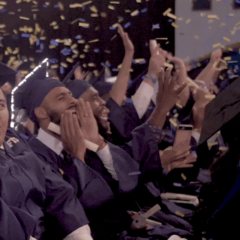 A group of people is cheering as confetti falls on them.